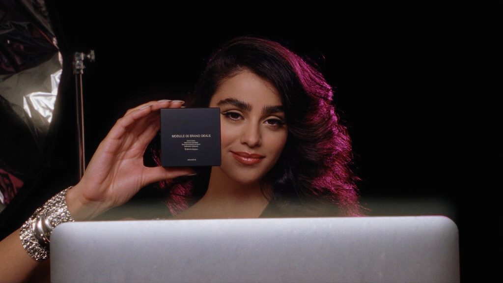 A model presenting a matte-black product box to the camera